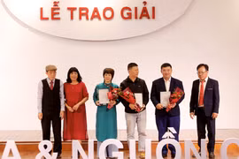 Ban Tổ chức trao giải Nhất cho các tác giả. (Ảnh: Khiếu Minh/Vietnam+)