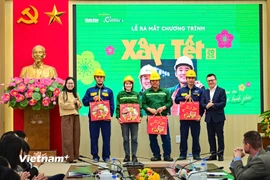 Ban Tổ chức trao quà tặng công nhân xây dựng của Coteccons và công nhân môi trường của Công ty TNHH Một thành viên Thoát nước Hà Nội. (Ảnh: CTV/Vietnam+)