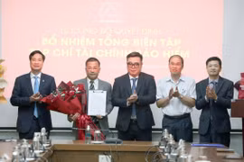 Cục trưởng Cục Quản lý, Giám sát Bảo hiểm Ngô Việt Trung, Phó Cục Trưởng Cục Quản lý, Giám sát Bảo hiểm Phạm Văn Đức, Chủ tịch Hiệp hội Bảo hiểm Việt Nam Nguyễn Xuân Việt và Tổng Thư ký Hiệp hội Bảo hiểm Việt Nam Phạm Ngọc Sơn, tặng hoa chúc mừng nhà báo Nguyễn Phong Cầm. (Ảnh: Tuấn Minh)