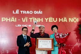 Ông Lê Quốc Minh, Ủy viên Trung ương Đảng, Chủ tịch Hội Nhà báo Việt Nam, Tổng Biên tập Báo Nhân Dân và Tổng Giám đốc Thông tấn xã Việt Nam Vũ Việt Trang trao Giải thưởng Lớn cho nhạc sỹ Trần Tiến. (Ảnh: Huy Thông/TTXVN)