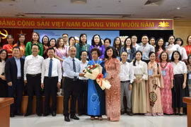 Các đại biểu và học viên chụp ảnh lưu niệm. (Ảnh: PV/Vietnam+)