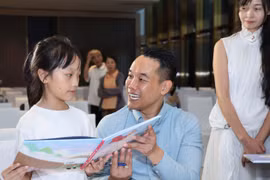 Tác giả Bùi Mạnh Hà ký tặng sách cho độc giả tại ngày hội “Vì những nụ cười trở lại” diễn ra ngày 24/5 tại Hà Nội. (Ảnh: PV/Vietnam+)