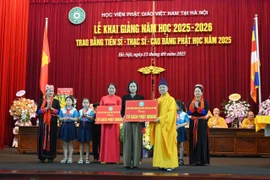 Hòa thượng Thích Thanh Quyết, Phó Chủ tịch Hội đồng Trị sự, Viện trưởng Học viện Phật giáo Việt Nam tại Hà Nội trao tặng sách cho đại diện các trường. (Ảnh: PV/Vietnam+)
