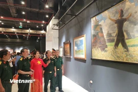 Họa sỹ Nguyễn Thu Thủy cùng các đại biểu tham quan triển lãm. (Ảnh: Minh Thu/Vietnam+)