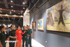 Họa sỹ Nguyễn Thu Thủy cùng các đại biểu tham quan triển lãm. (Ảnh: Minh Thu/Vietnam+)