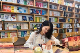 Tác giả Ngọc Trần ký tặng sách cho độc giả. (Ảnh: NVCC)