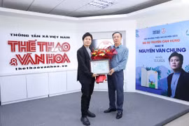 Nhà báo Nguyễn Thiện Thuật, Tổng Biên tập Báo Thể thao và Văn hóa trao hoa và Bằng chứng nhận Đại sứ truyền cảm hứng cho nhạc sỹ Nguyễn Văn Chung (trái). (Ảnh: PV/Vietnam+)