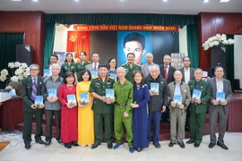 Tác giả trao tặng cuốn sách cho Bảo tàng Phụ nữ Việt Nam và các đại biểu, cựu chiến binh. (Ảnh: PV/Vietnam+)