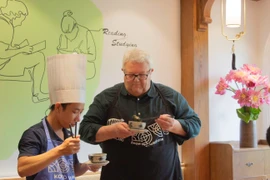 Chủ tịch Quốc hội New Zealand Gerry Brownlee nếm món thịt bò cuốn lá lốt. (Ảnh: PV/Vietnam+)