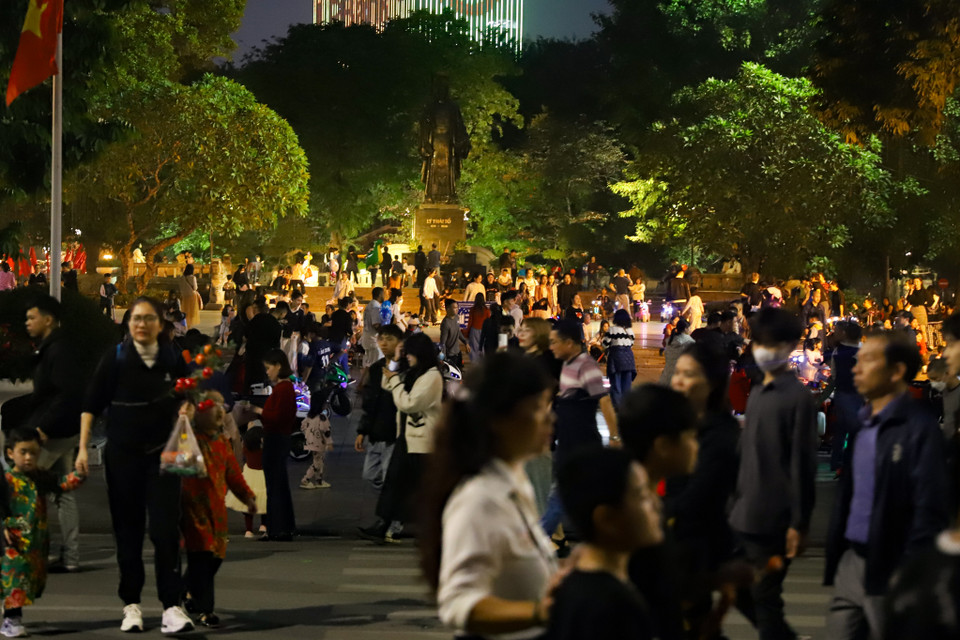 Buổi tối cuối cùng của năm cũ, người dân hòa mình vào dòng người tấp nập tại phố đi bộ Hồ Gươm (Hoàn Kiếm, Hà Nội) đón chờ thời khắc giao thừa. (Ảnh: Hoài Nam/Vietnam+)