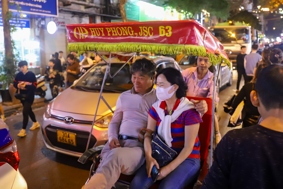 Du khách nước ngoài lựa chọn xích lô để ngắm phố phường Hà Nội trong ngày cuối cùng năm. (Ảnh: Hoài Nam/Vietnam+)