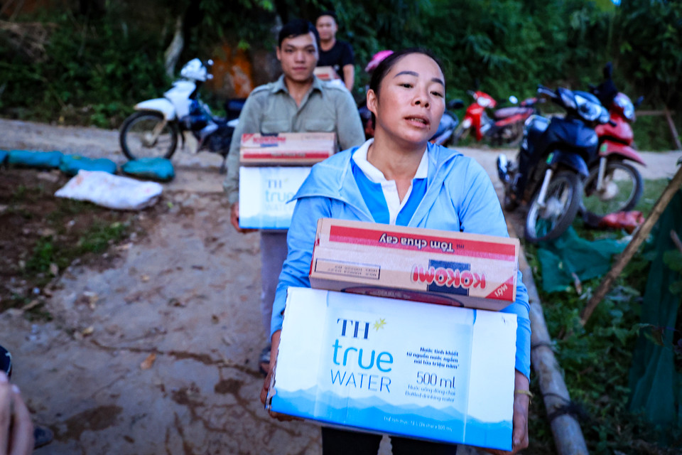 Mì tôm và nước sạch được vận chuyển đến từng bản làng, trao tận tay người dân thuộc huyện Bát Xát tỉnh Lào Cai - nơi vừa trải qua lũ và sạt lở đất. Nhờ đó, người dân được tiếp thêm sức mạnh để chống chọi với thiên tai. (Ảnh: Hoài Nam/Vietnam+)