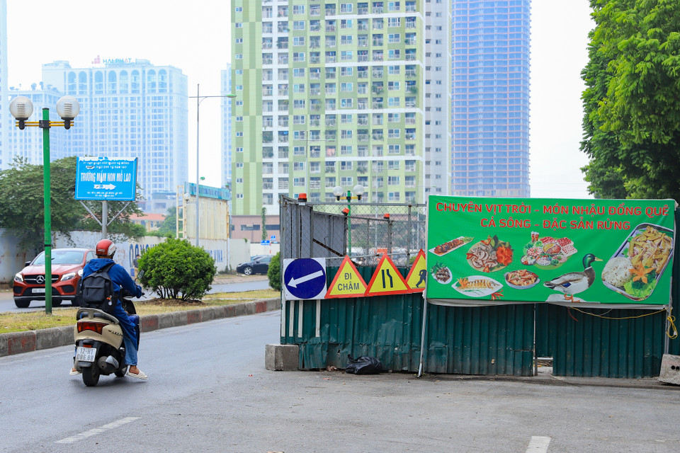 Theo ghi nhận của phóng viên Báo Điện tử VietnamPlus sáng ngày 28/7, phía bên ngoài một số vị trí quây tôn trở thành nơi treo biển quảng cáo của người dân. (Ảnh: Hoài Nam/Vietnam+) 