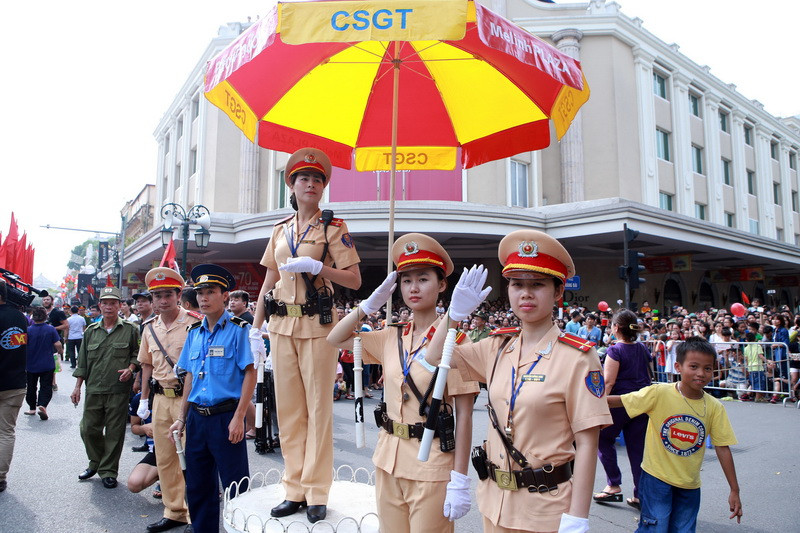 Các nữ chiến sĩ Cảnh sát Giao thông phân luồng trên đường phố khi đoàn Diễu binh đi qua (Nguồn: TTXVN)