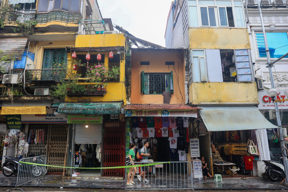 Tương tự, khu vực số nhà 60 Hàng Đường (Hàng Đào, Hoàn Kiếm, Hà Nội) cũng bị ảnh hưởng do cơn bão số 3 nhưng chưa được giải quyết, lực lượng chức năng đã lập rào chắn, hạn chế khu vực nguy hiểm tại đây. (Ảnh: Hoài Nam/Vietnam+)