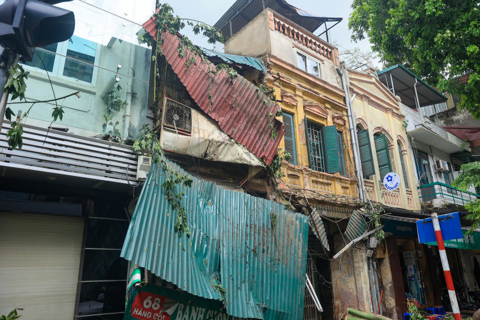 Theo ghi nhận của phóng viên, tại số nhà 68 Hàng Cót (Hàng Mã, Hoàn Kiếm, Hà Nội), phần mái tôn bị cây đổ trúng trong cơn bão vẫn đang lơ lửng, phần bên trong ngôi nhà cũng bị ảnh hưởng. (Ảnh: Hoài Nam/Vietnam+)