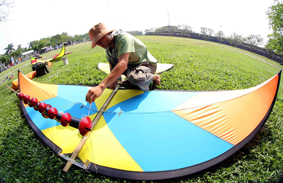 Nghệ nhân chuẩn bị cho sáo diều trước giờ bay (Ảnh: Trần Lê Lâm - TTXVN)