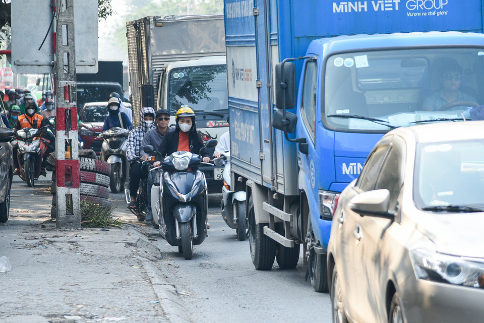 Khi xảy ra ùn tắc kéo dài xe máy, xe đạp điện phải luồn lách, tìm khoảng trống giữa hàng dài ôtô. (Ảnh: PV/Vietnam+)