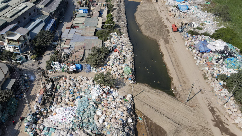 Ngay từ đầu làng, những "núi" rác nhựa được chất kín, cao hàng chục mét ở khắp các con đường. (Ảnh: Hoài Nam/Vietnam+)