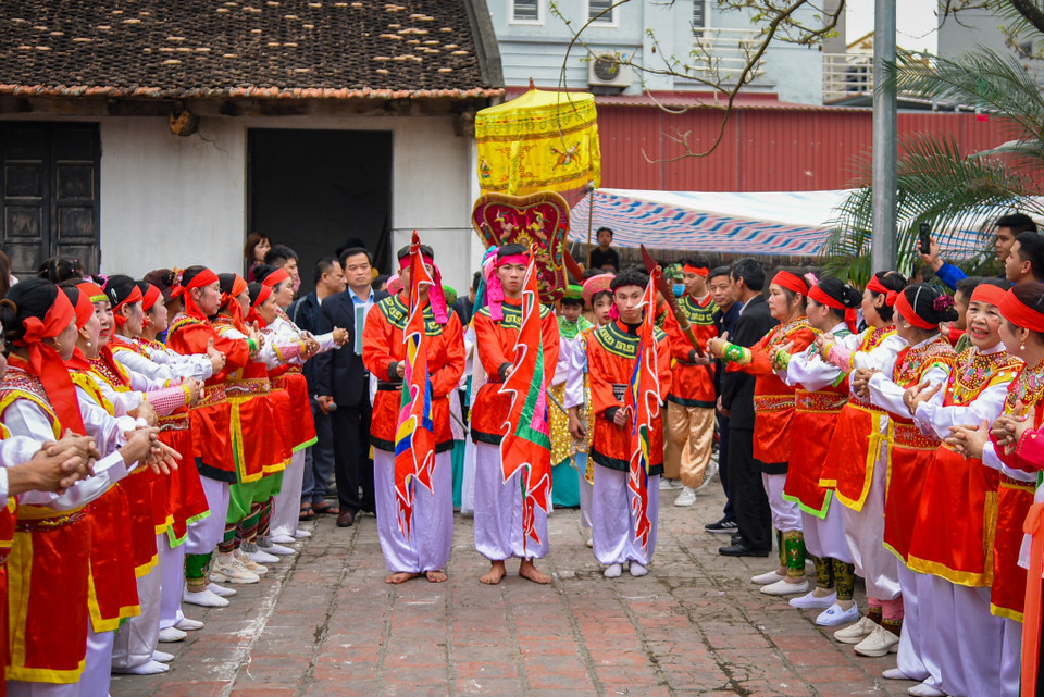Màn vinh quy bái tổ mở đầu cho lễ hội. Một đoàn rước kiệu bà Lê Hoa đi từ cổng làng vào sân đình, hai bên có các bô lão trong làng đón ‘Đức Thánh Bà’ xuống kiệu. (Ảnh: PV/Vietnam+)