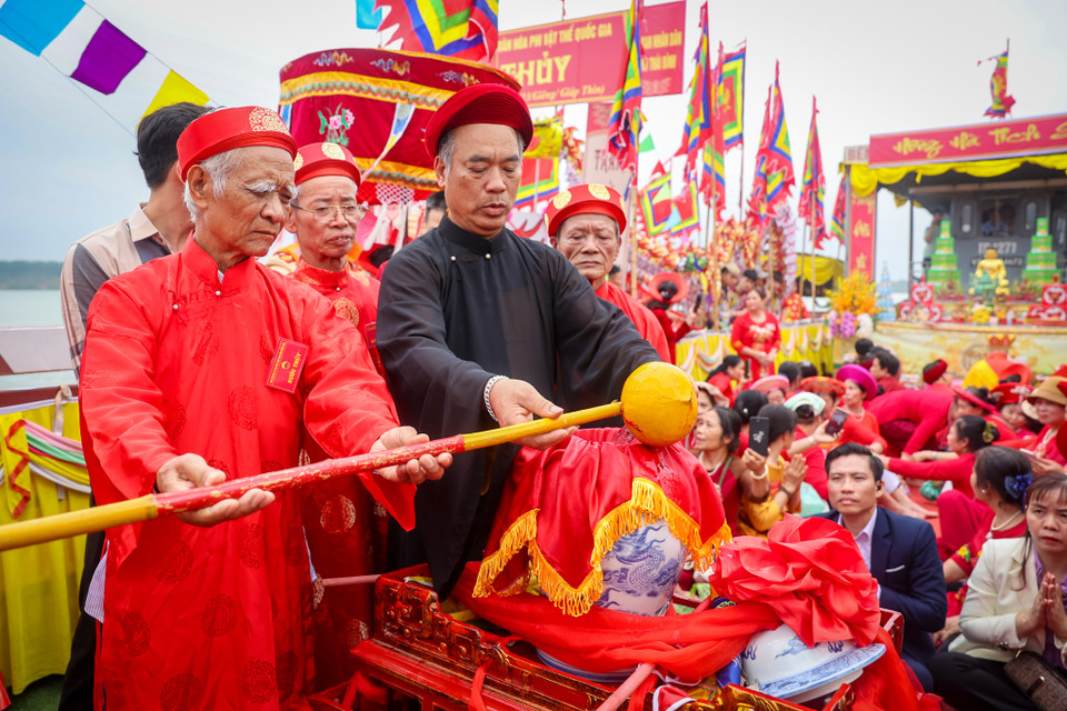 Đến ngã ba Tuần Vường, từng gàu nước được các cụ cao niên và các vị chư tăng trút vào chum nhỏ. (Ảnh: Hoài Nam/Vietnam+)