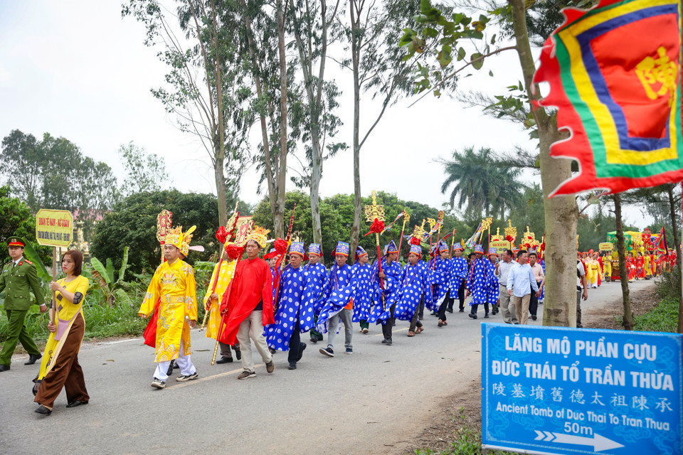 Đoàn rước đi đến đâu đều có đoàn bát âm, cờ trống theo đến đó. Người dân tham gia lễ hội cùng đi theo thành hàng dài với mong muốn được tận mắt chứng kiến lễ rước linh thiêng cũng như cầu cho một năm mưa thuận gió hòa. (Ảnh: Hoài Nam/Vietnam+)