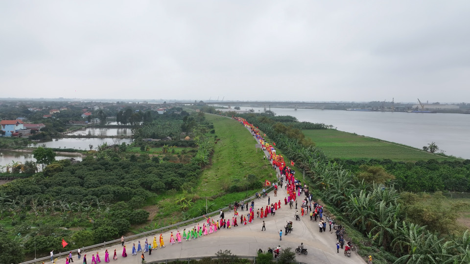 Mùa lễ hội năm 2024, lễ rước nước thu hút 76 đoàn với trên 2.000 người tham dự. Hình ảnh đoàn rước đi thành hàng dài ven đê với trống rong cờ mở rợp trời tạo nên khung cảnh sinh động, đầy màu sắc. (Ảnh: Hoài Nam/Vietnam+)