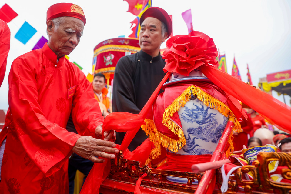 Chum nước được cẩn trọng đặt lên bành, dùng dây lụa đỏ chằng buộc cẩn thận để tránh bị đổ trong khi khiêng kiệu. (Ảnh: Hoài Nam/Vietnam+)