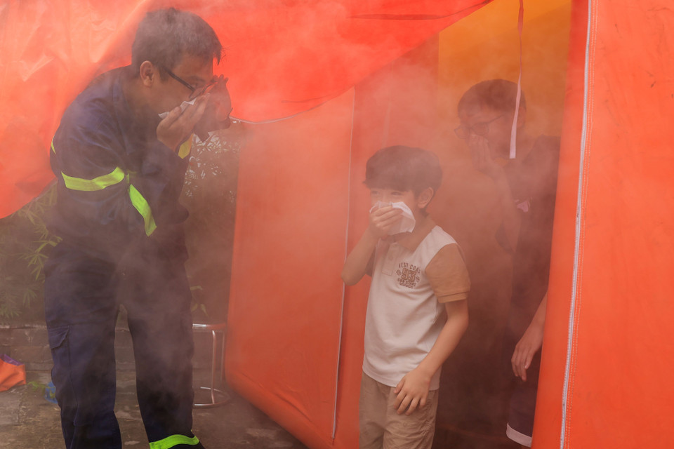 Bên cạnh tìm hiểu về kiến thức an toàn phòng cháy, các em nhỏ còn được trải nghiệm các hoạt động như thoát hiểm bằng thang dây, thoát hiểm qua môi trường khói trong đám cháy. (Ảnh: Hoài Nam/Vietnam+)