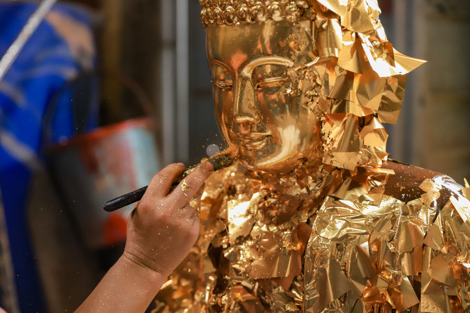 Tùy theo nhu cầu của khách hàng mà công đoạn cuối người thợ sẽ dán bạc hoặc dán vàng quỳ. (Ảnh: Hoài Nam/Vietnam+)