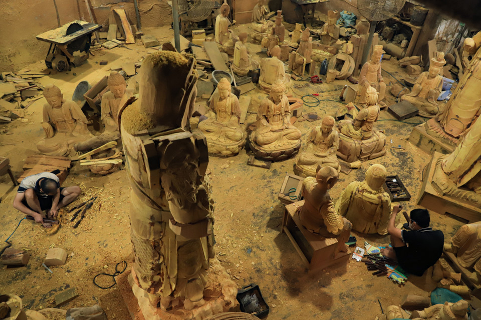 Vào những ngày gần cuối năm, khắp làng nghề Sơn Đồng (Hoài Đức, Hà Nội) nhộn nhịp, xưởng sản xuất tượng và đồ thờ nào cũng vang tiếng đục đẽo lách cách. (Ảnh: Hoài Nam/Vietnam+)