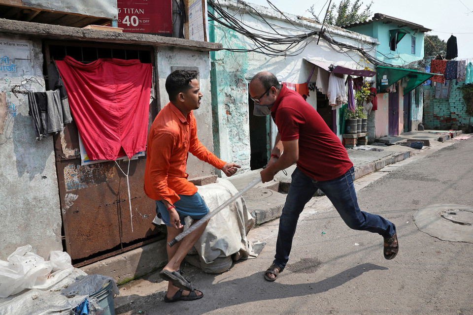 Một người vi phạm ở Kolkata bị cảnh sát vụt vào chân (Nguồn: Reuters)