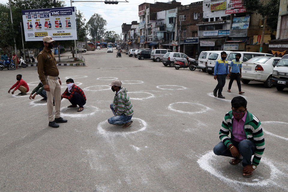 Những người bị phạt ngồi trong vòng tròn để nhận thức thế nào về 'giãn cách xã hội' (Nguồn: Reuters)