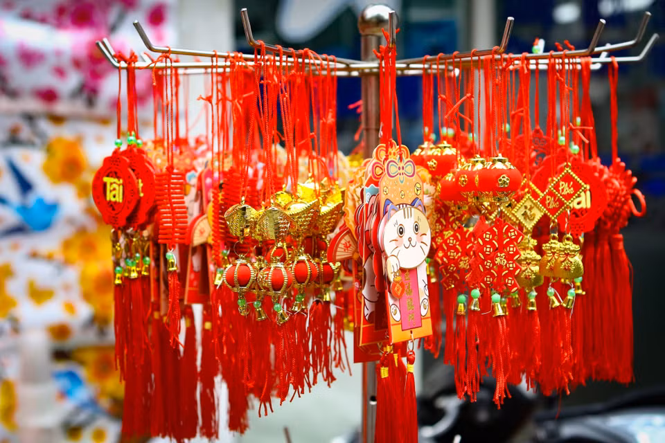 Câu đối, lời chúc,... cũng được nhiều gia đình tìm mua để treo lên cành đào, cây quất. Giá bán dao động từ 50.000 - 120.000 đồng/sản phẩm tùy kích thước. (Ảnh: Hoài Nam/Vietnam+)
