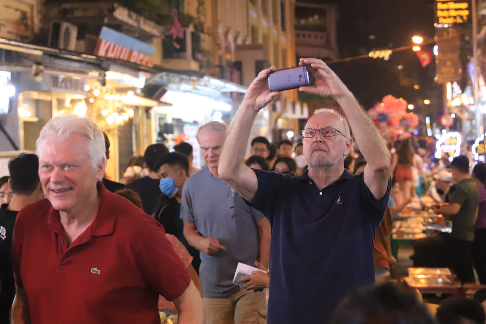 Du khách nước ngoài ghi lại những hình ảnh náo nhiệt trên 'phố Tây' Tạ Hiện trong buổi khai mạc Worrld Cup. (Ảnh: Hoài Nam/Vietnam+)