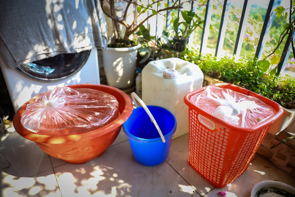 Gia đình anh Ứng, phòng 418 tòa HH03B đã nghĩ ra cách đựng nước vào túi nilon đặt trong rổ nhựa, chậu hoa để sử dụng lâu dài. (Ảnh: Hoài Nam/Vietnam+)