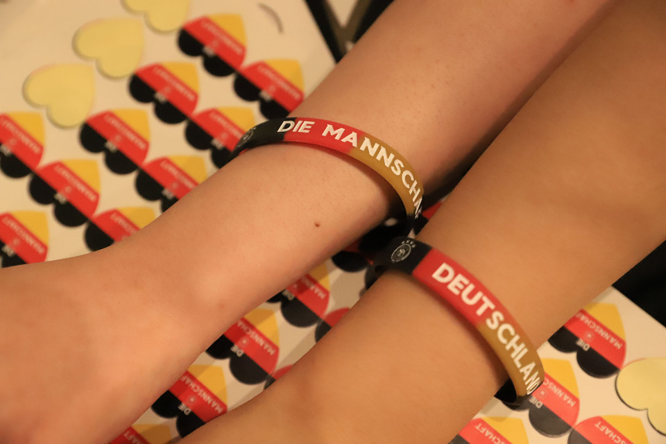 Những chiếc vòng tay và sticker lá cờ Đức được ban tổ chức chuẩn bị cho người hâm mộ đến tham gia cổ vũ. (Ảnh: PV/Vietnam+)