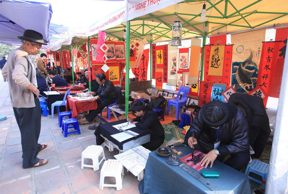 Mỗi gian nhà bạt sẽ bố trí 2 “ông Đồ” viết chữ, có bàn, ghế ngồi, có niêm yết giá công khai. (Ảnh: Anh Tuấn - TTXVN)