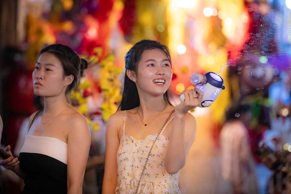 Nhiều bạn trẻ lựa chọn chơi Trung Thu sớm, hòa chung vào không khí nhộn nhịp trên phố Hàng Mã. (Ảnh: Hoài Nam/Vietnam+)