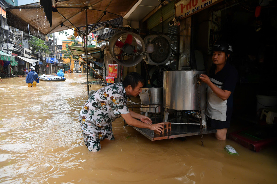 Người dân kê kích những đồ đạc không thể di tản được để tránh ngập nước. (Ảnh: PV/Vietnam+)