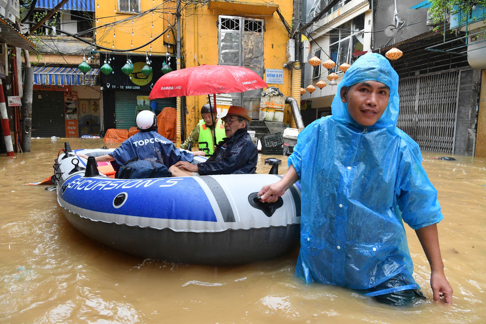 Nhiều hộ gia đình phải sơ tán bằng thuyền. (Ảnh: PV/Vietnam+)