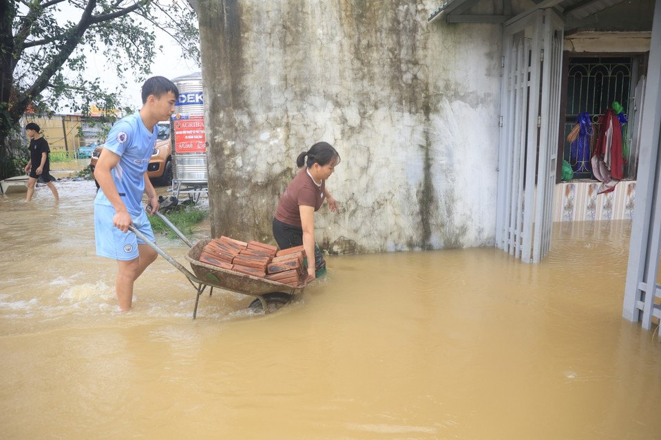 Người dân Nam Phương Tiến (Chương Mỹ, Hà Nội) chuẩn bị gạch để kê cao những vật dụng trong nhà, tránh hỏng hóc. (Ảnh: Hoài Nam/Vietnam+)