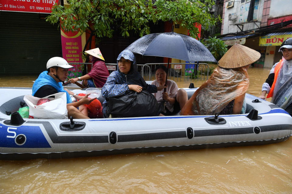 Nhiều hộ gia đình rời khỏi vùng ngập trong chiều 11/9. (Ảnh: PV/Vietnam+)