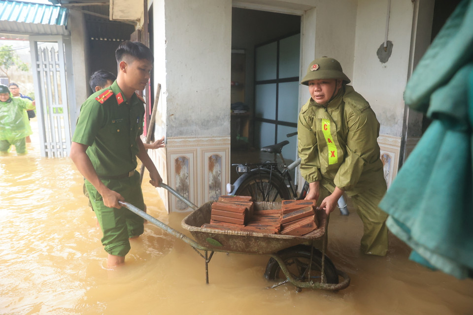 Chính quyền địa phương hỗ trợ người dân vùng bị lụt. (Ảnh: Hoài Nam/Vietnam+)