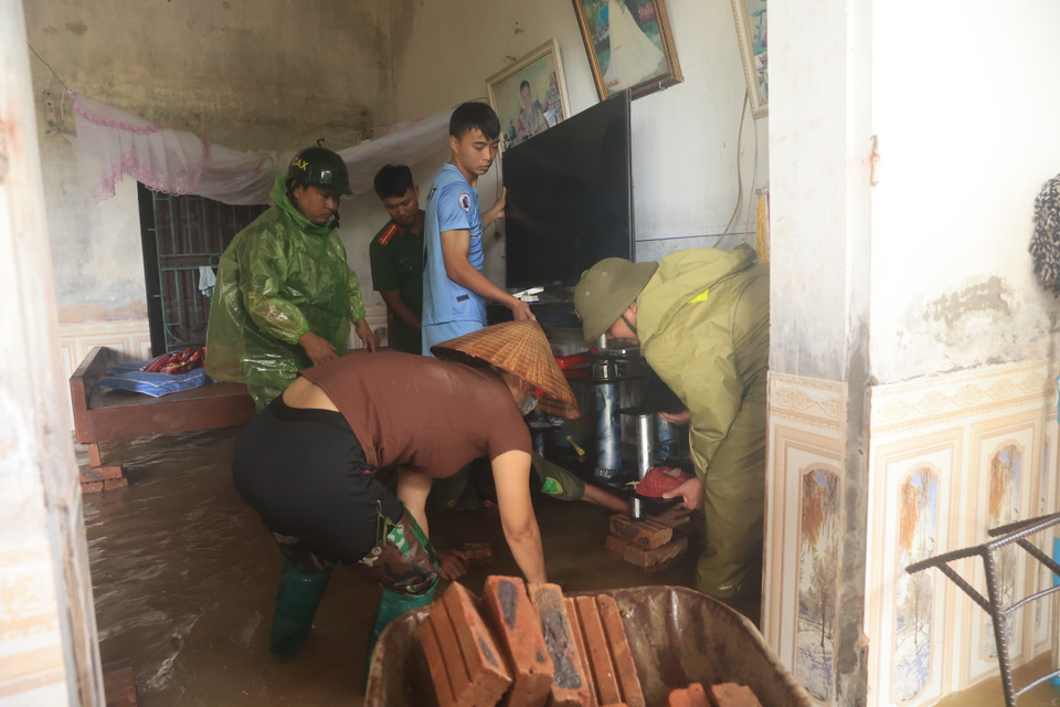 Lực lượng công an xã hỗ trợ người dân kê kích đồ đạc. Tính đến thời điểm 11 giờ 11/9, nước vẫn tiếp tục dâng kèm mưa lớn. (Ảnh: Hoài Nam/Vietnam+)