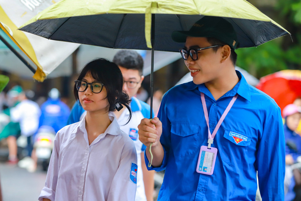 Sinh viên tình nguyện đội mưa tiếp sức sĩ tử kỳ thi tốt nghiệp Trung học phổ thông 2023. (Ảnh: PV/Vietnam+)