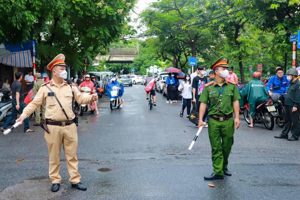 Cảnh sát giao thông phối hợp điều tiết giao thông cùng công an phường Hoàng Liệt tại điểm thi trường Trung học Cơ sở Hoàng Liệt. (Ảnh: PV/Vietnam+)