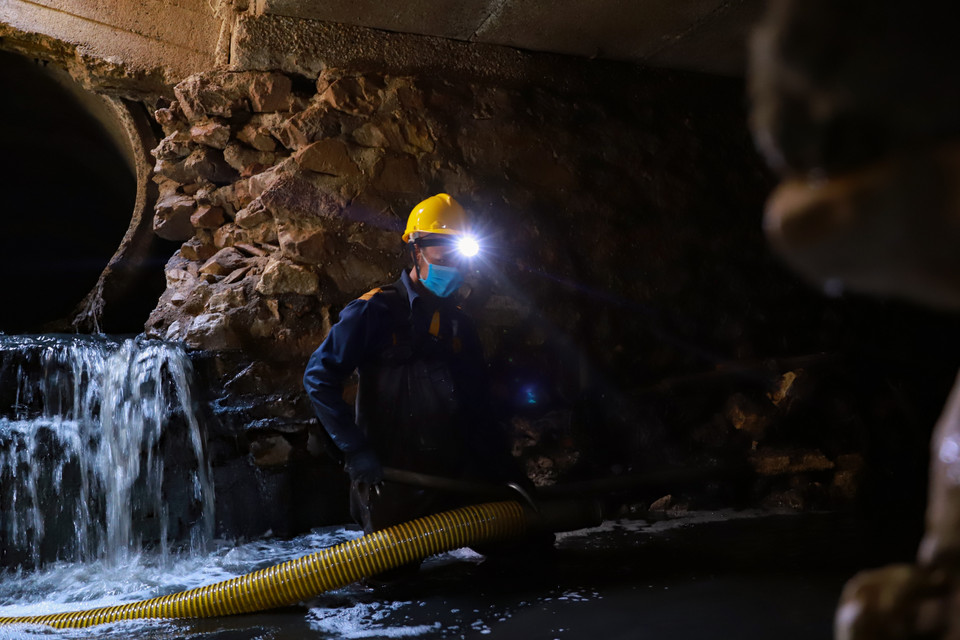 Sau khi hút đủ bùn, phần bã sẽ được giữ lại trong xe hút phía trên. Phần nước sẽ được xả lại trong lòng cống. ‘Lực đẩy nước lúc này rất lớn, không trụ vững thế đứng là chúng tôi có thể ngụp lặn luôn trong cống’- anh Trị nói. (Ảnh: Hoài Nam/Vietnam+)