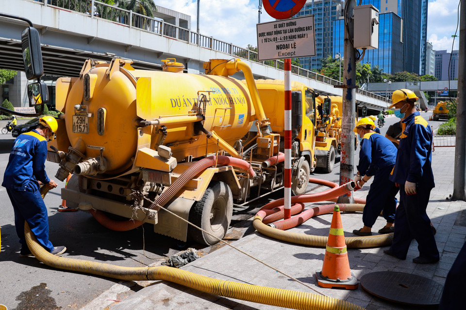 Các công nhân làm việc dưới điều kiện nắng nóng và dưới cống ngầm không khí độc hại. 1 tổ dây chuyền thực hiện nạo vét có 10-12 xe hút, 1 xe phản lực, 3 xe téc và 1 xe nước. (Ảnh: Hoài Nam/Vietnam+)