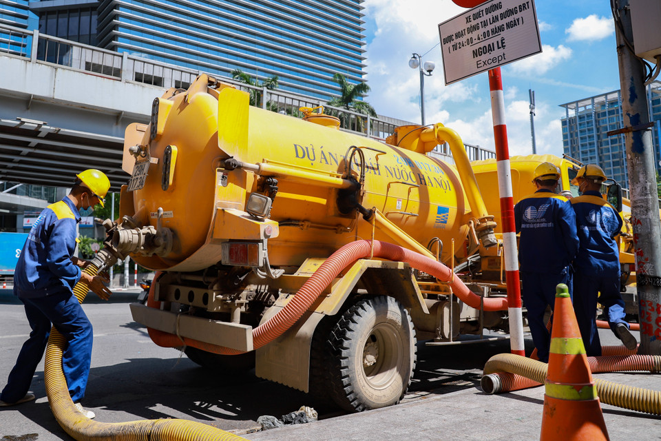 9 giờ sáng, tổ công nhân của Xí nghiệp thi công Cơ giới Xây lắp thuộc công ty Thoát nước Hà Nội (Công ty TNHH MTV Thoát nước Hà Nội) đã có mặt tại nút giao Láng Hạ-Thái Hà để chuẩn bị một ngày làm việc trong ‘thế giới ngầm.’ (Ảnh: Hoài Nam/Vietnam+)